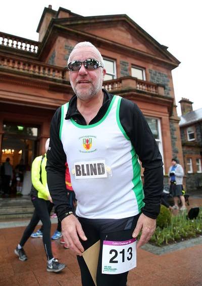 Tony taking part in a run in a city location. Tony has a running bib on and is number 213